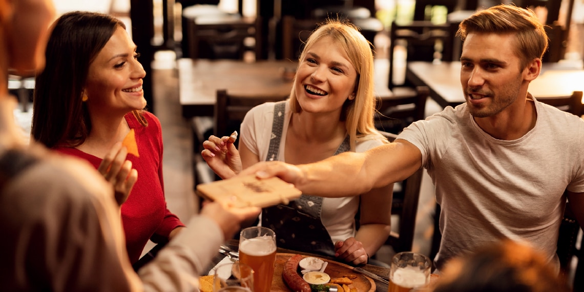 Photo of person paying restaurant bill for the group with his credit card.