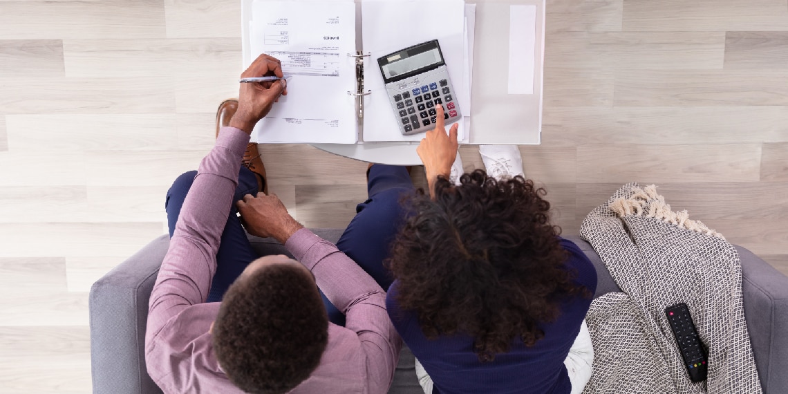 Photo of young African American couple looking over their finances.