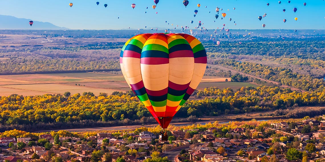 Aerial view of Albuquerque, New Mexico with hot air balloons in the sky.