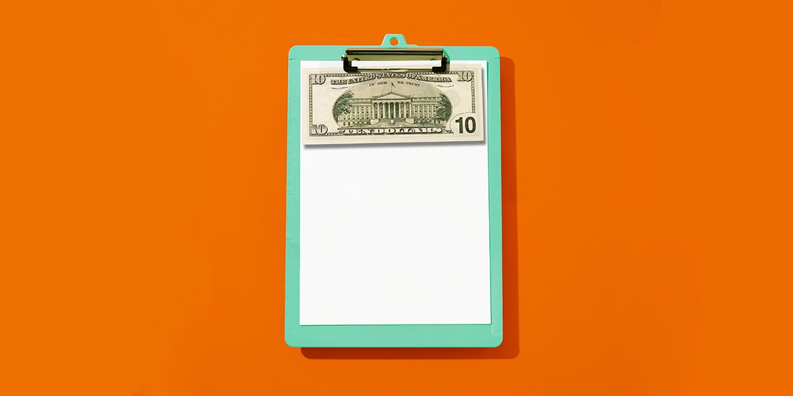 A clipboard with a ten dollar bill attached.