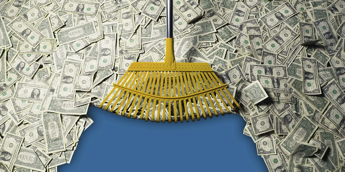 A rake sweeping up dollar bills.